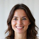 Portrait of a smiling woman in her 30s, looking healthy and happy, representing 'Sarah P'.